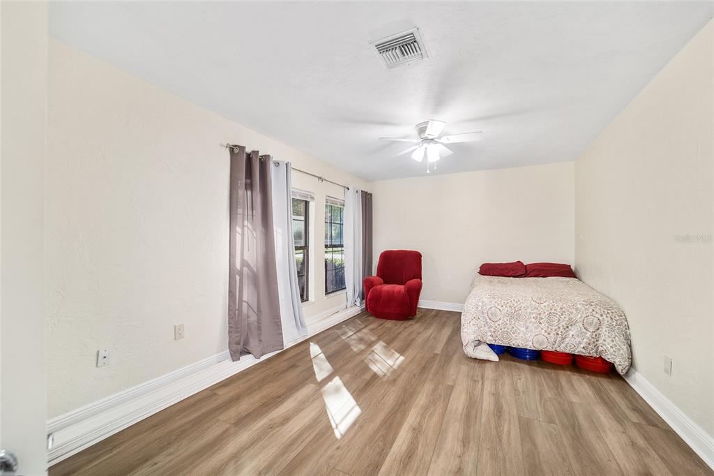 5201 East Jasmine Lane Inverness, FL 34453 - Photo 32 of 50 a bedroom with a bed and a chandelier