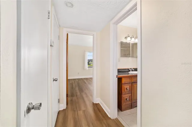 a view of a room with wooden floor and a ceiling fan