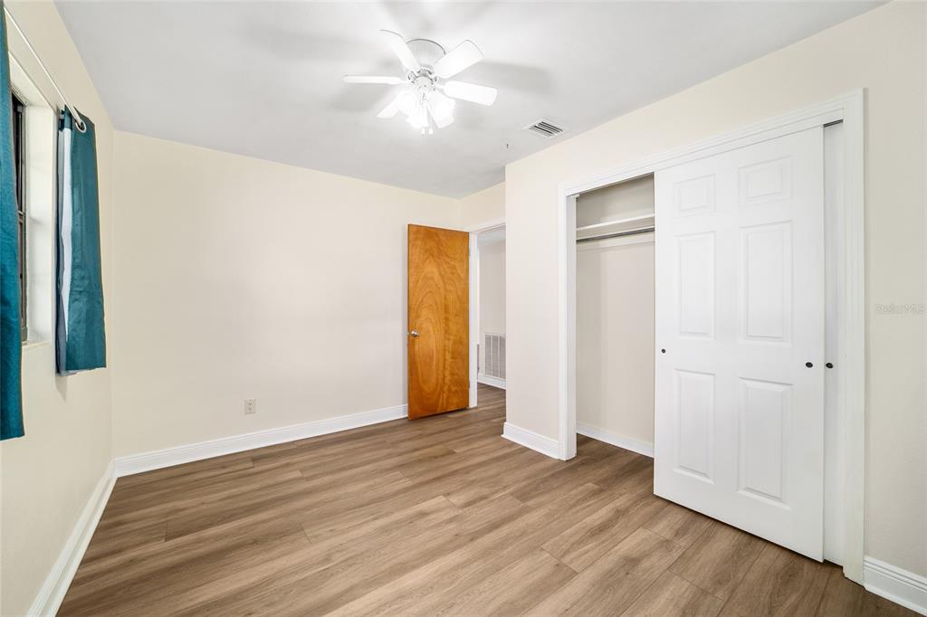 5201 East Jasmine Lane Inverness, FL 34453 - Photo 40 of 50 an empty room with wooden floor and a ceiling fan