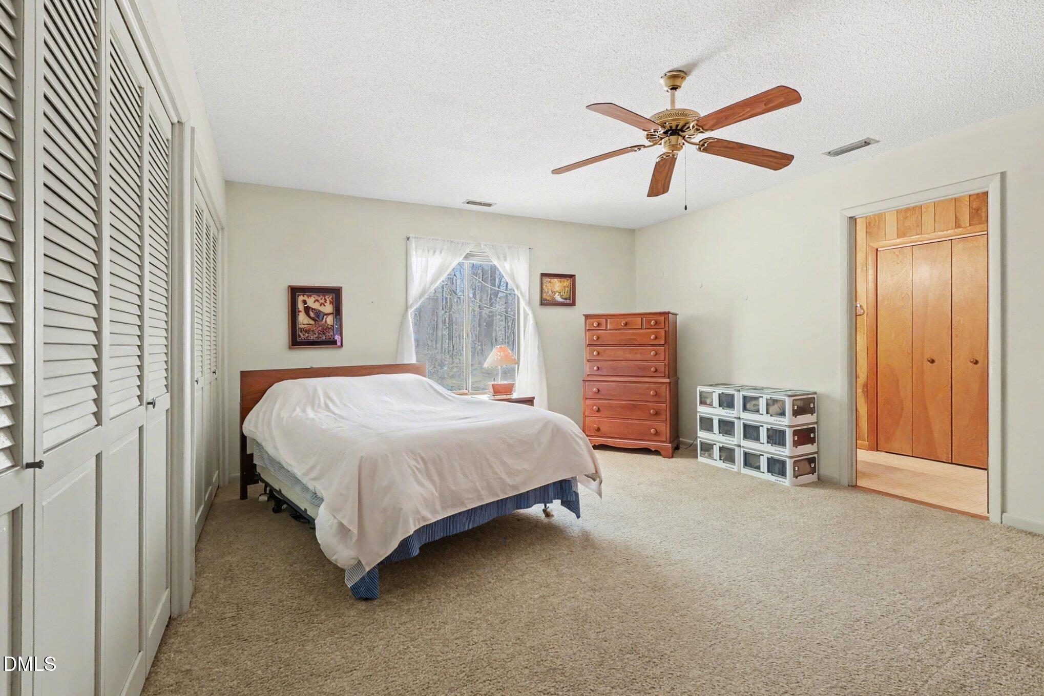 5702 Old Greensboro Road Chapel Hill, NC 27516 - Photo 19 of 43 a bedroom with a bed and a chandelier