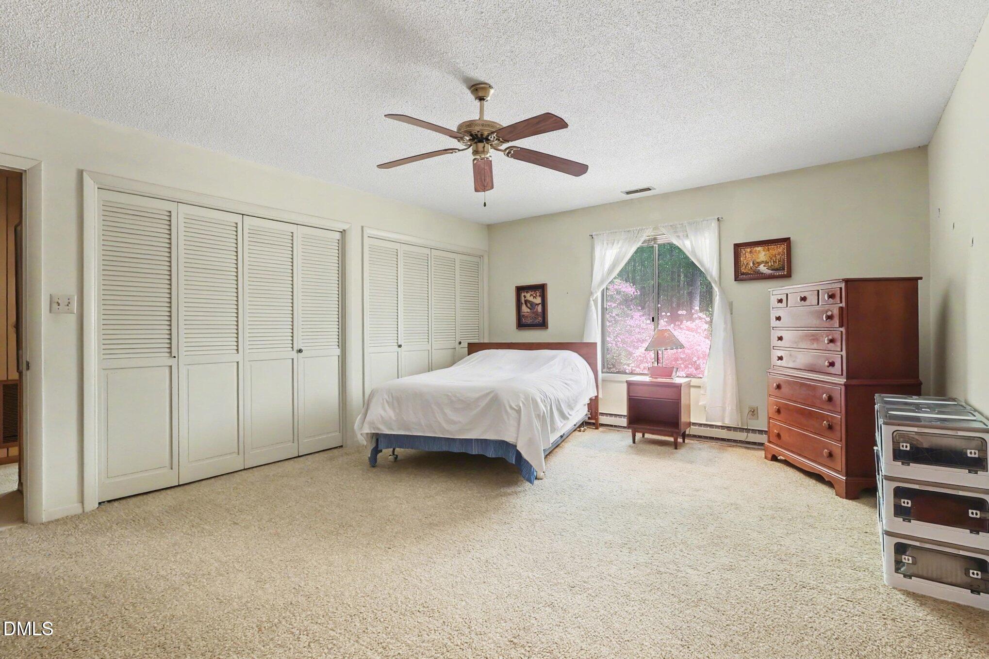 5702 Old Greensboro Road Chapel Hill, NC 27516 - Photo 20 of 43 a spacious bedroom with a bed and dresser