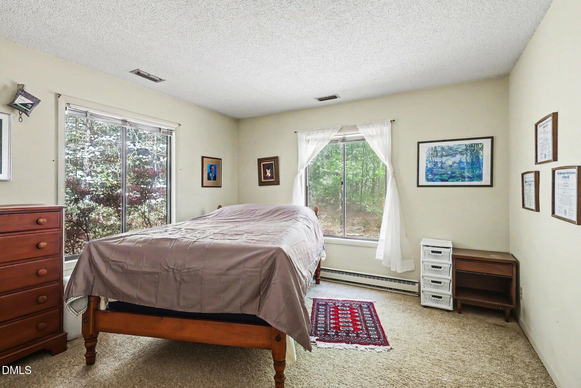 5702 Old Greensboro Road Chapel Hill, NC 27516 - Photo 22 of 43 a bed sitting in a bedroom next to a window