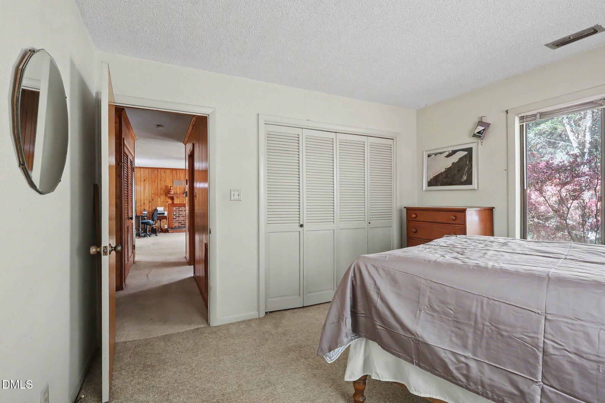 5702 Old Greensboro Road Chapel Hill, NC 27516 - Photo 23 of 43 a bedroom with a bed and a chandelier