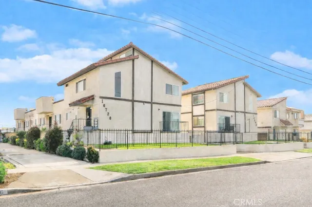 a view of white house with a big yard and large trees