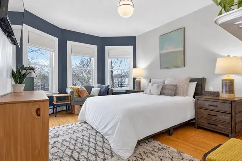 a bedroom with a bed and large windows