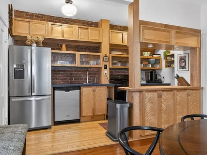 a kitchen with stainless steel appliances granite countertop a refrigerator and a stove top oven
