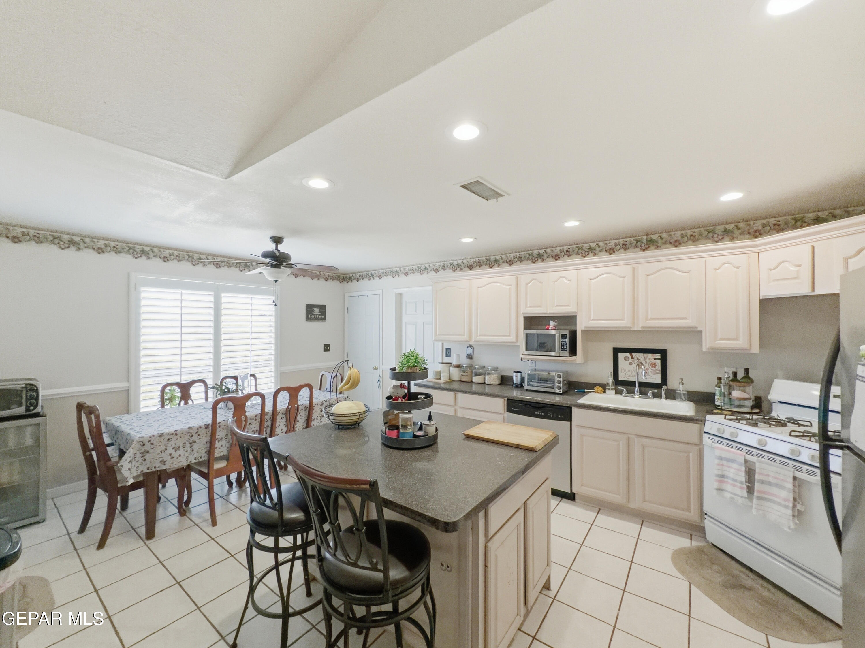 5156 Bradley Road El Paso, TX 79938 - Photo 14 of 39 a kitchen with stainless steel appliances kitchen island granite countertop a stove a sink a dining table and chairs