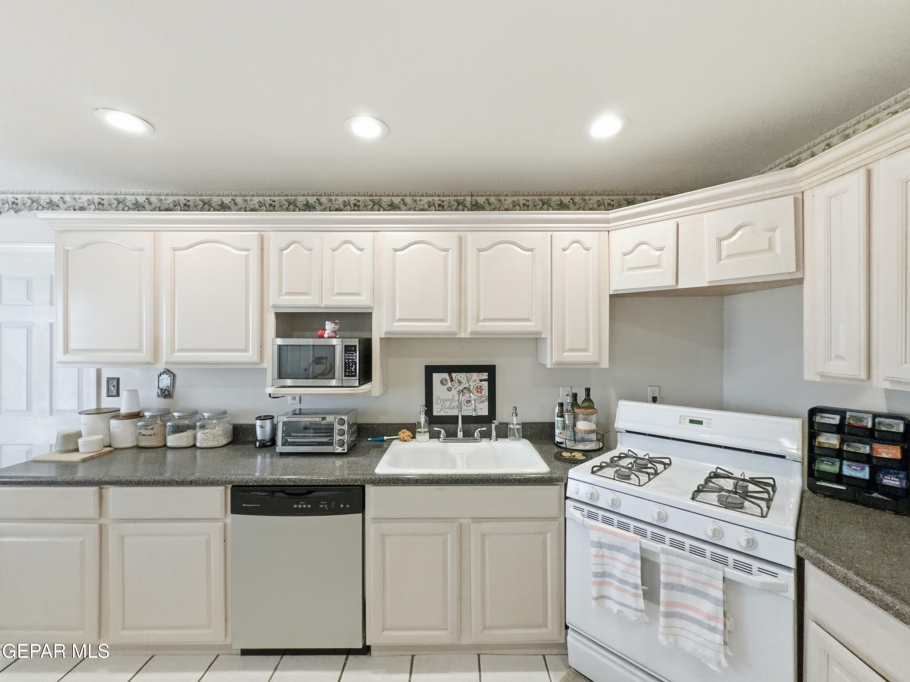 5156 Bradley Road El Paso, TX 79938 - Photo 15 of 39 a kitchen with white cabinets and appliances