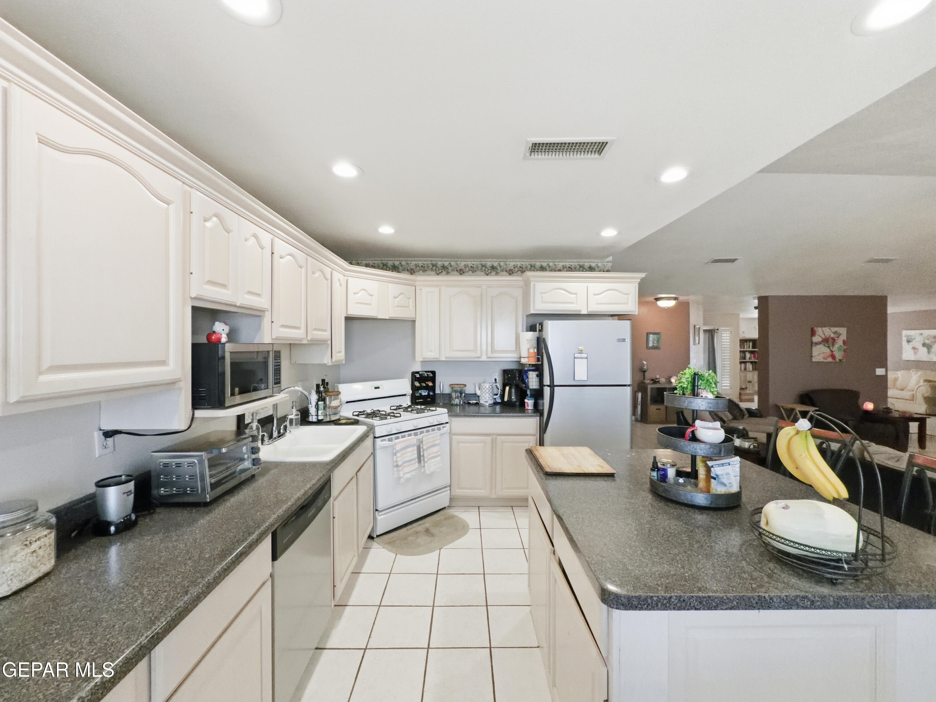 5156 Bradley Road El Paso, TX 79938 - Photo 16 of 39 a kitchen with sink refrigerator stove dining table and chairs