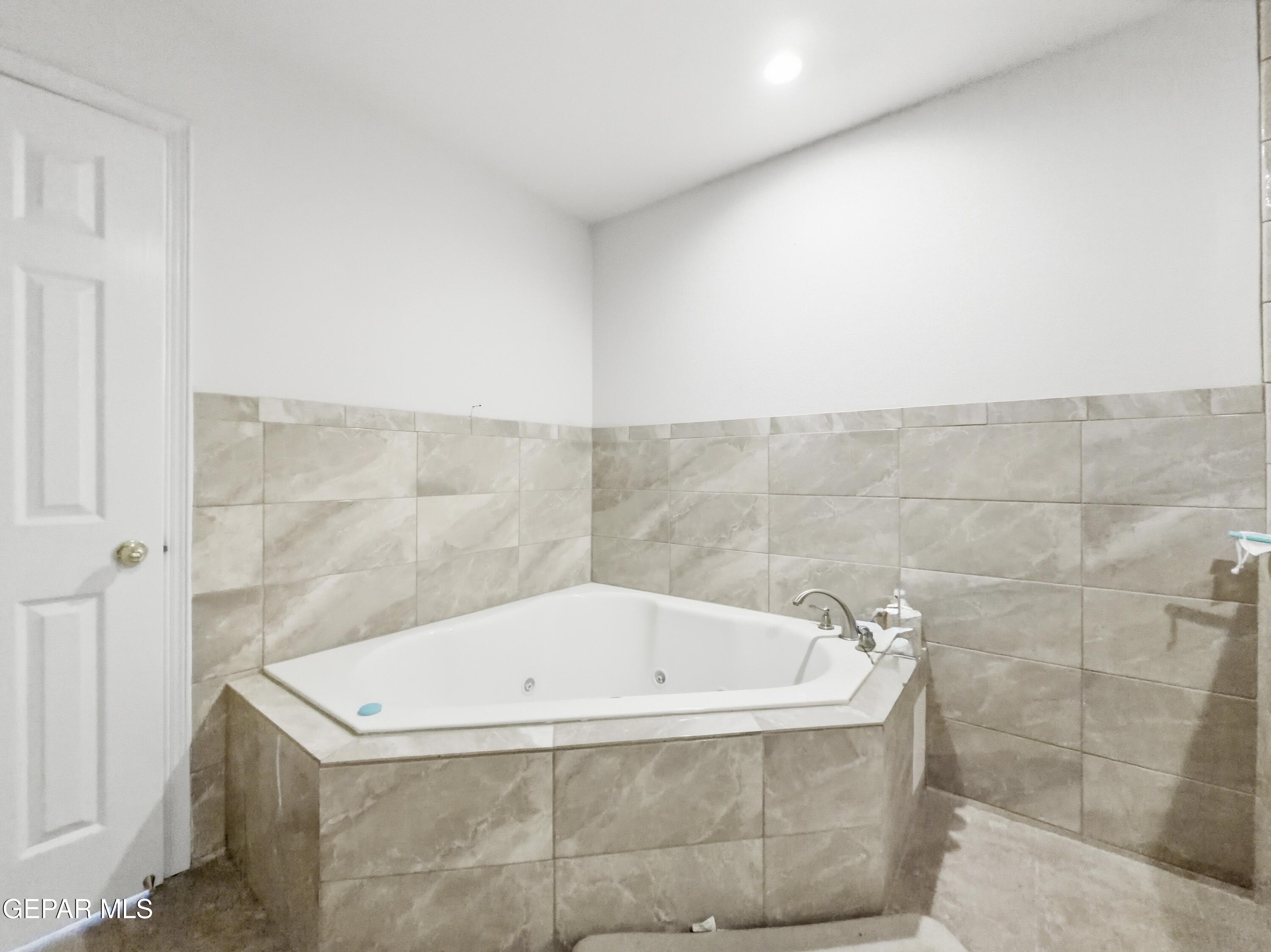 5156 Bradley Road El Paso, TX 79938 - Photo 30 of 39 a white bath tub sitting in a bathroom