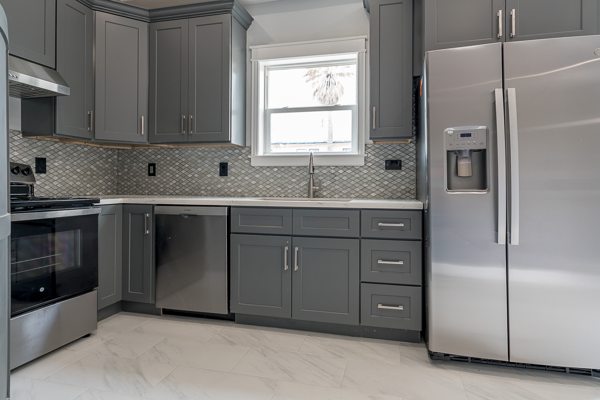 1801 Rosenberg Street, Unit 204 Galveston, TX 77550 - Photo 5 of 27 a kitchen with stainless steel appliances granite countertop a refrigerator and a sink