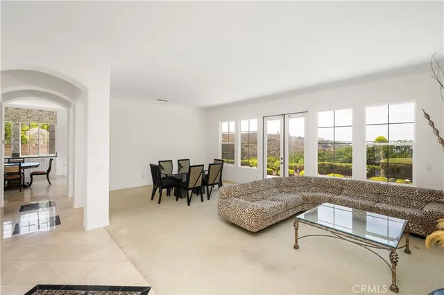 a dining room with furniture and large windows
