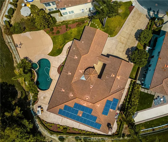 an aerial view of a house with swimming pool and outdoor seating