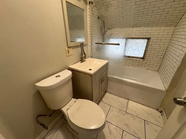a white toilet sitting next to a bath tub