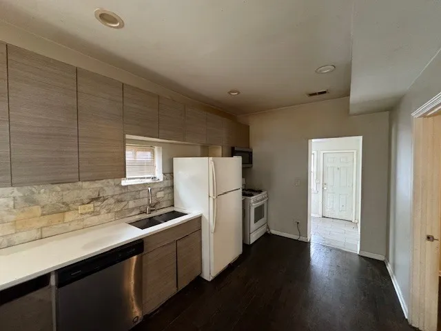 a kitchen with a refrigerator and a sink