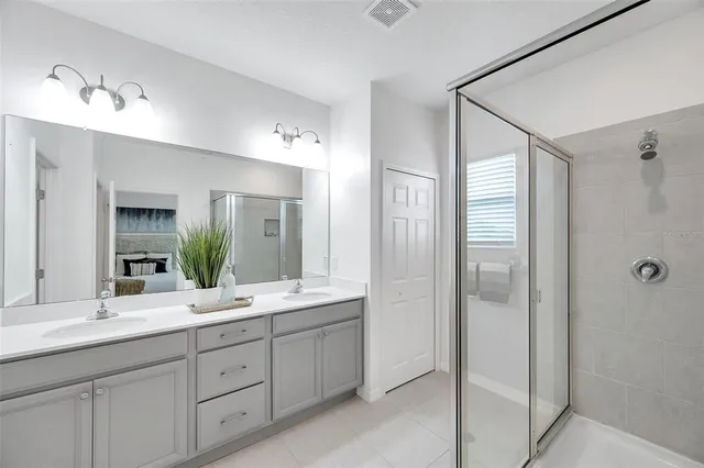 a spacious bathroom with a double vanity sink shower and mirror