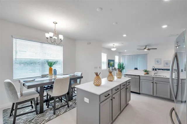 a kitchen with a dining table chairs sink and cabinets