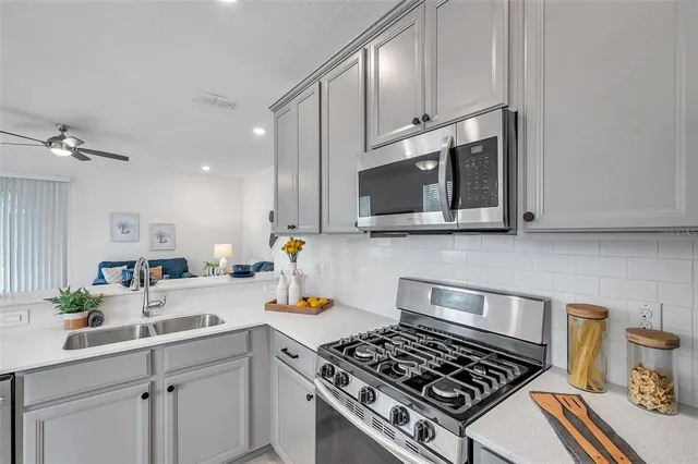 a kitchen with stainless steel appliances a sink a stove and cabinets