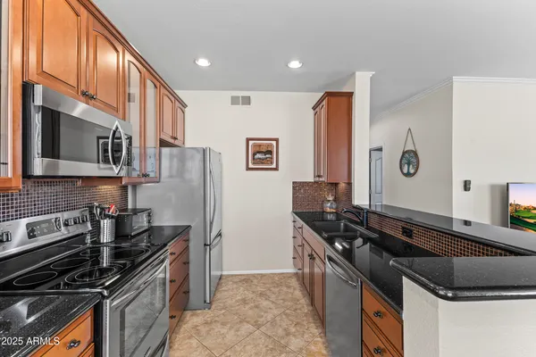 a kitchen with stainless steel appliances granite countertop a sink and a stove