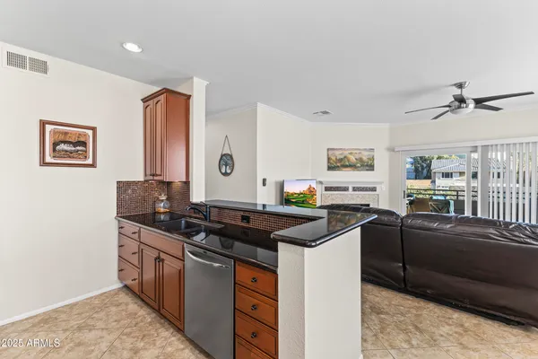 a kitchen with stainless steel appliances granite countertop a refrigerator a sink dishwasher a stove and a dining table with wooden floor