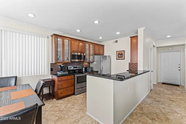 a kitchen with stainless steel appliances granite countertop a refrigerator and a stove top oven