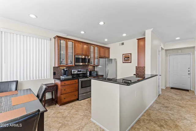 a kitchen with stainless steel appliances granite countertop a refrigerator and a stove top oven