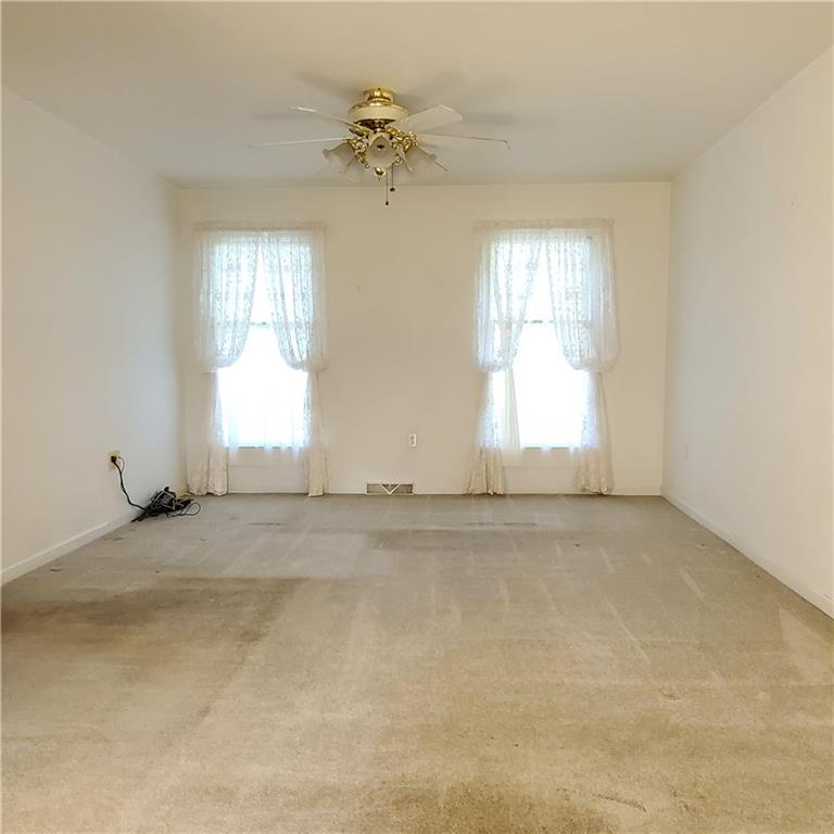 266 Catalpa Road Chicora, PA 16025 - Photo 7 of 23 an empty room with windows and chandelier fan