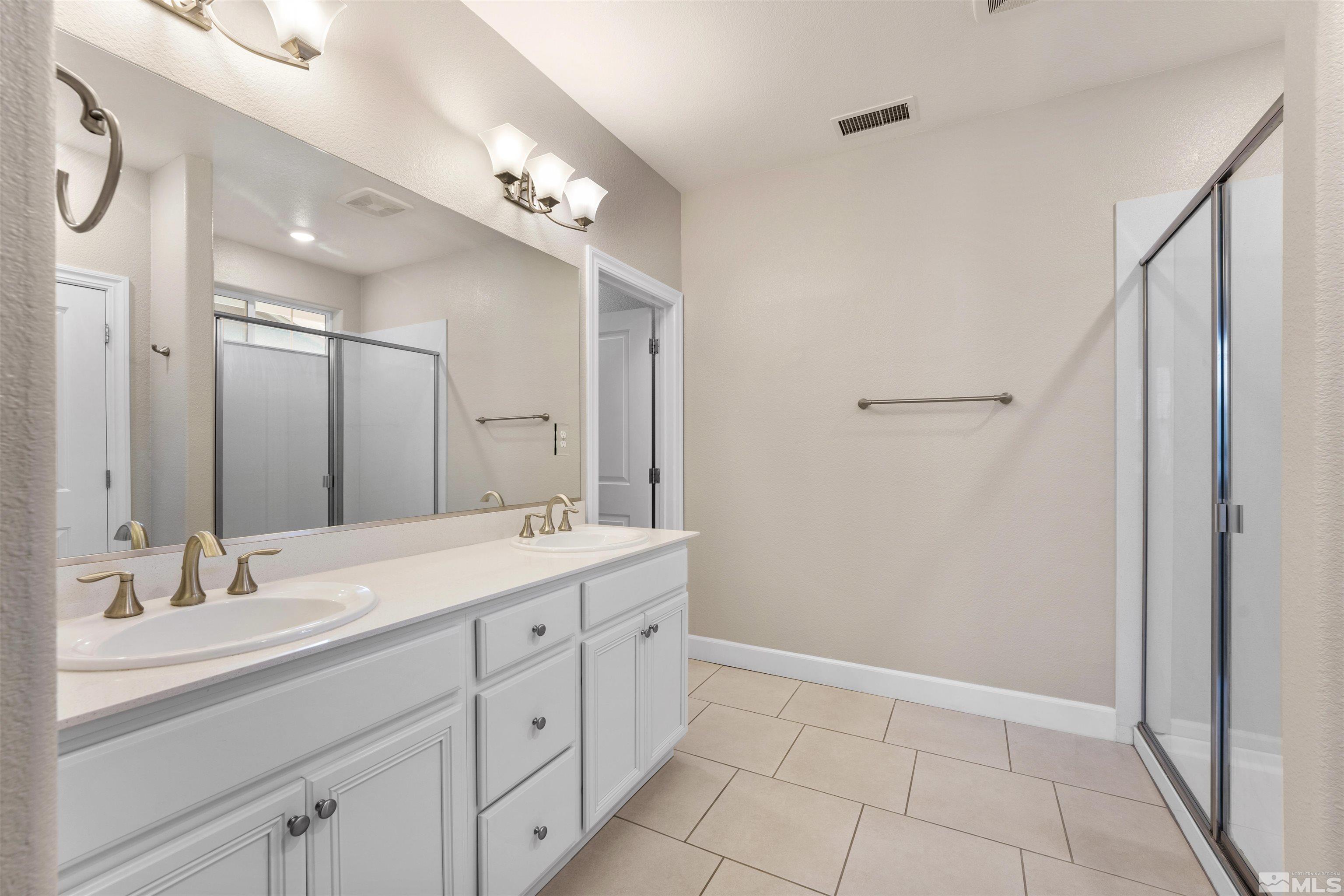 1945 Sea Horse Road, Unit A Reno, NV 89521 - Photo 14 of 25 a bathroom with a double vanity sink mirror and shower