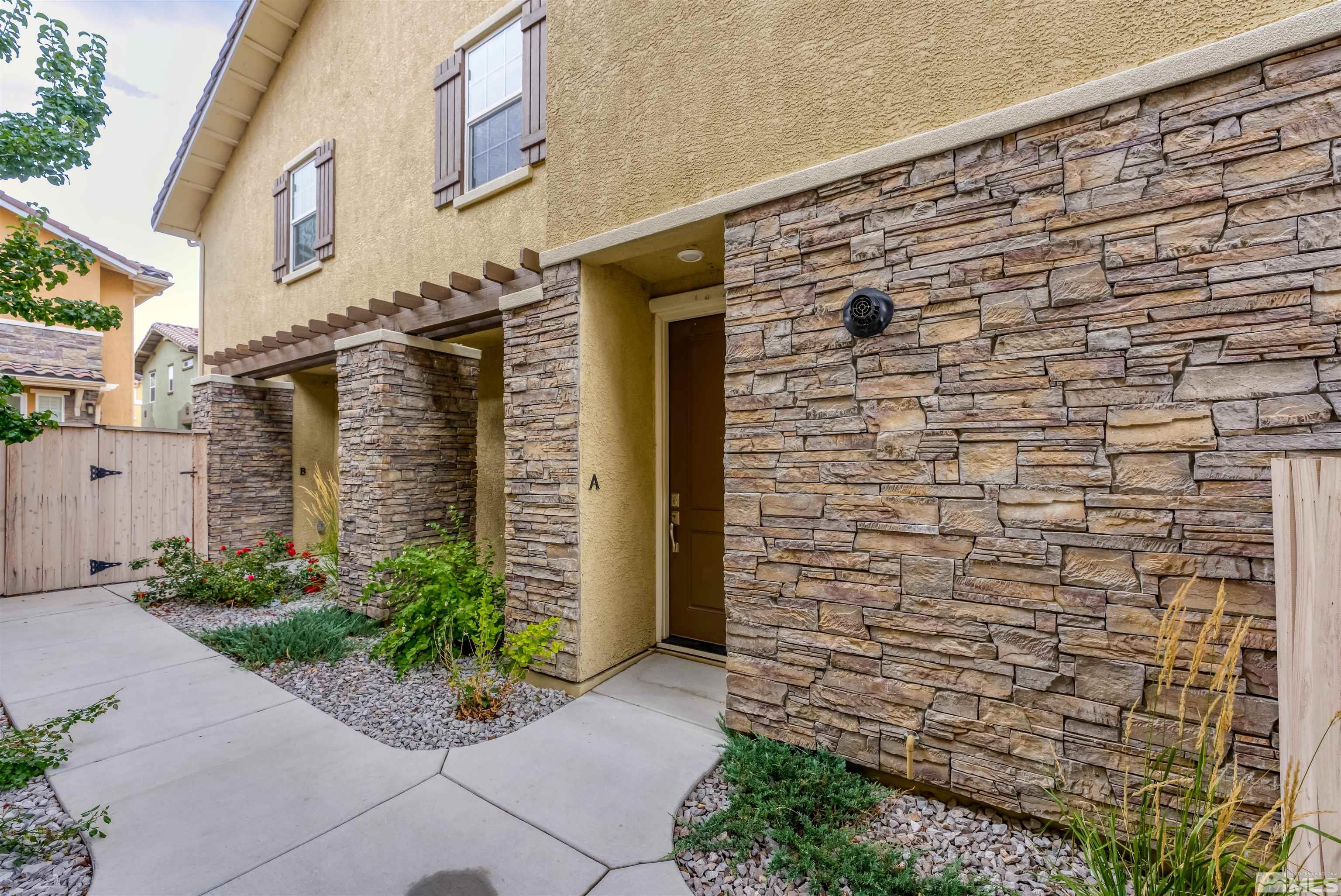 1945 Sea Horse Road, Unit A Reno, NV 89521 - Photo 25 of 25 a brick building with a window and potted plants