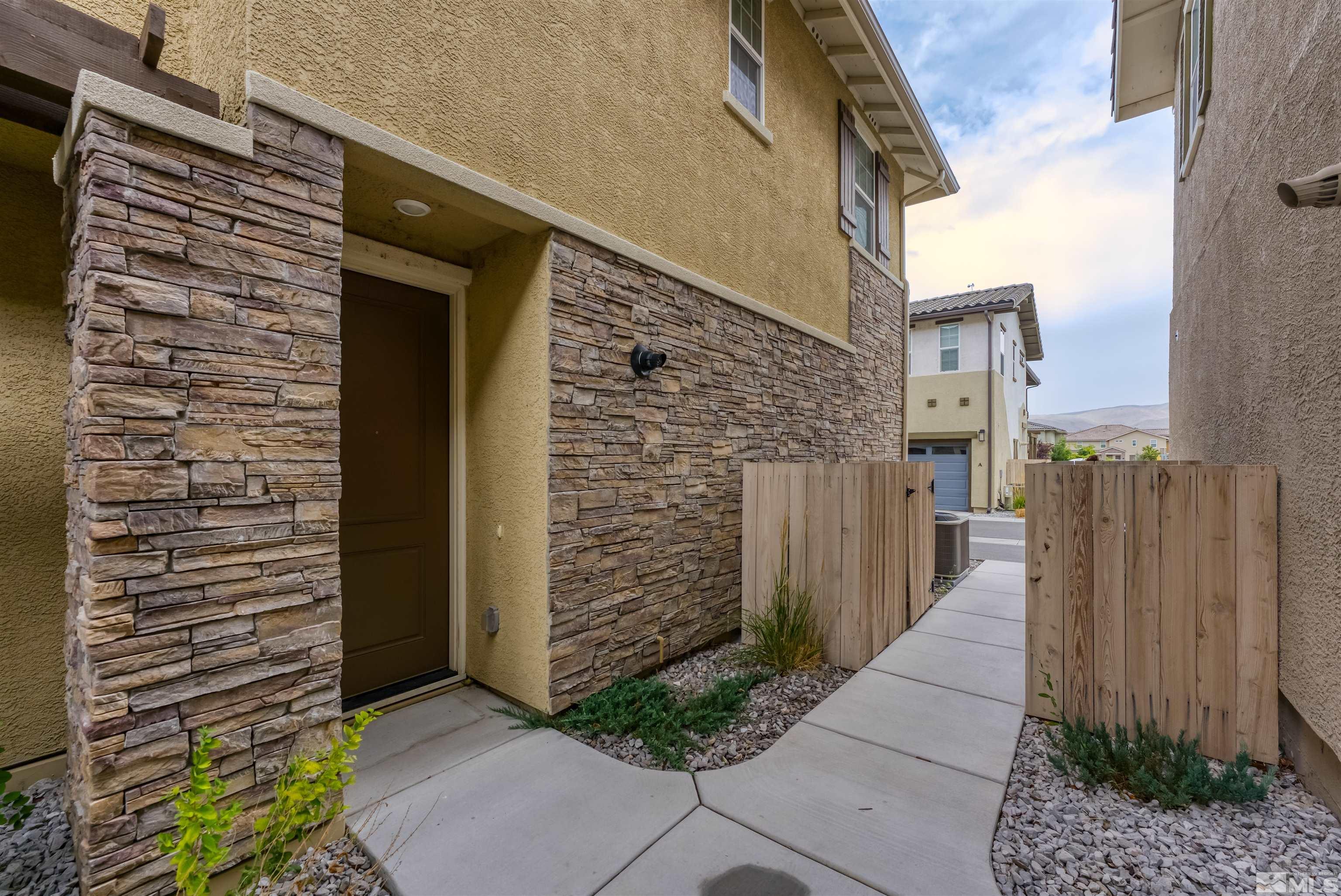 1945 Sea Horse Road, Unit A Reno, NV 89521 - Photo 4 of 25 a brick building with a window and a yard