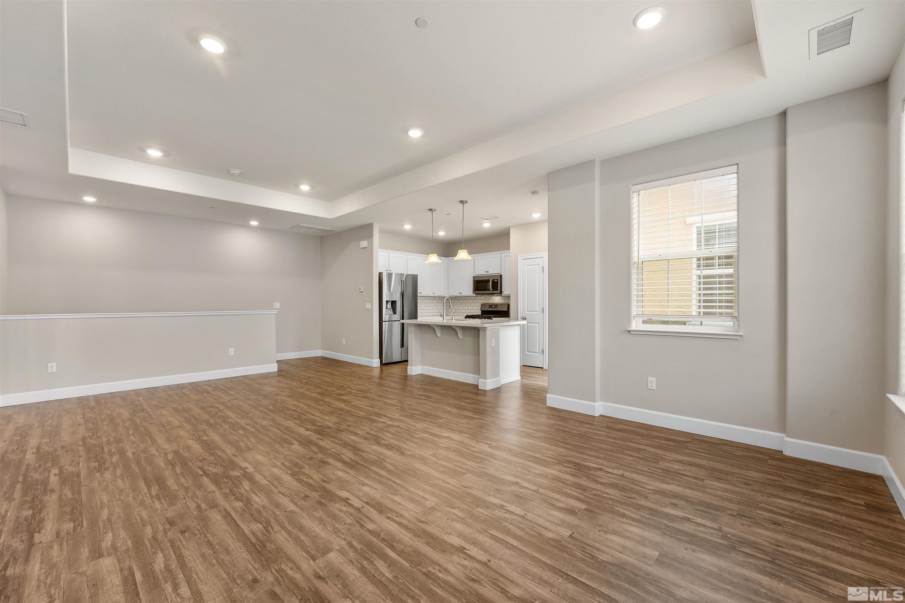 1945 Sea Horse Road, Unit A Reno, NV 89521 - Photo 6 of 25 a view of an empty room with a window and wooden floor