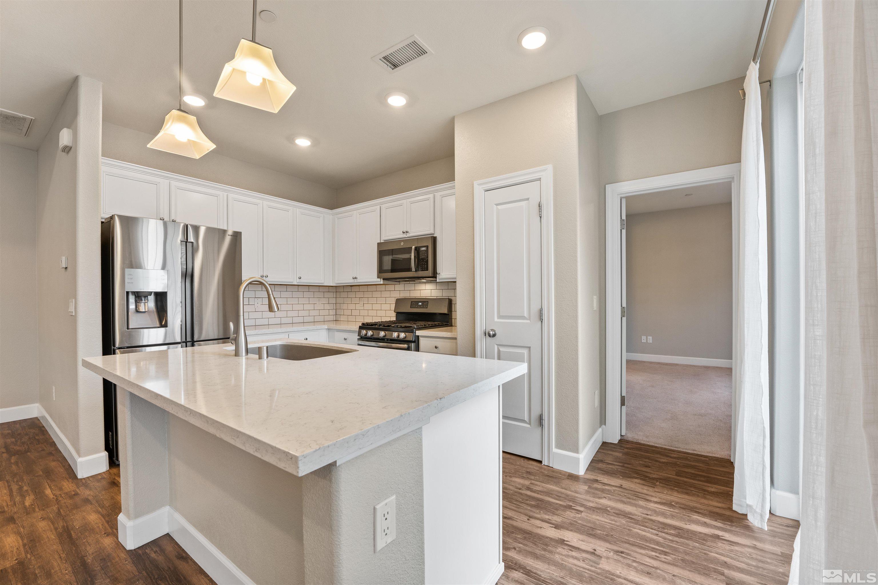 1945 Sea Horse Road, Unit A Reno, NV 89521 - Photo 8 of 25 a kitchen with kitchen island a sink stainless steel appliances and refrigerator