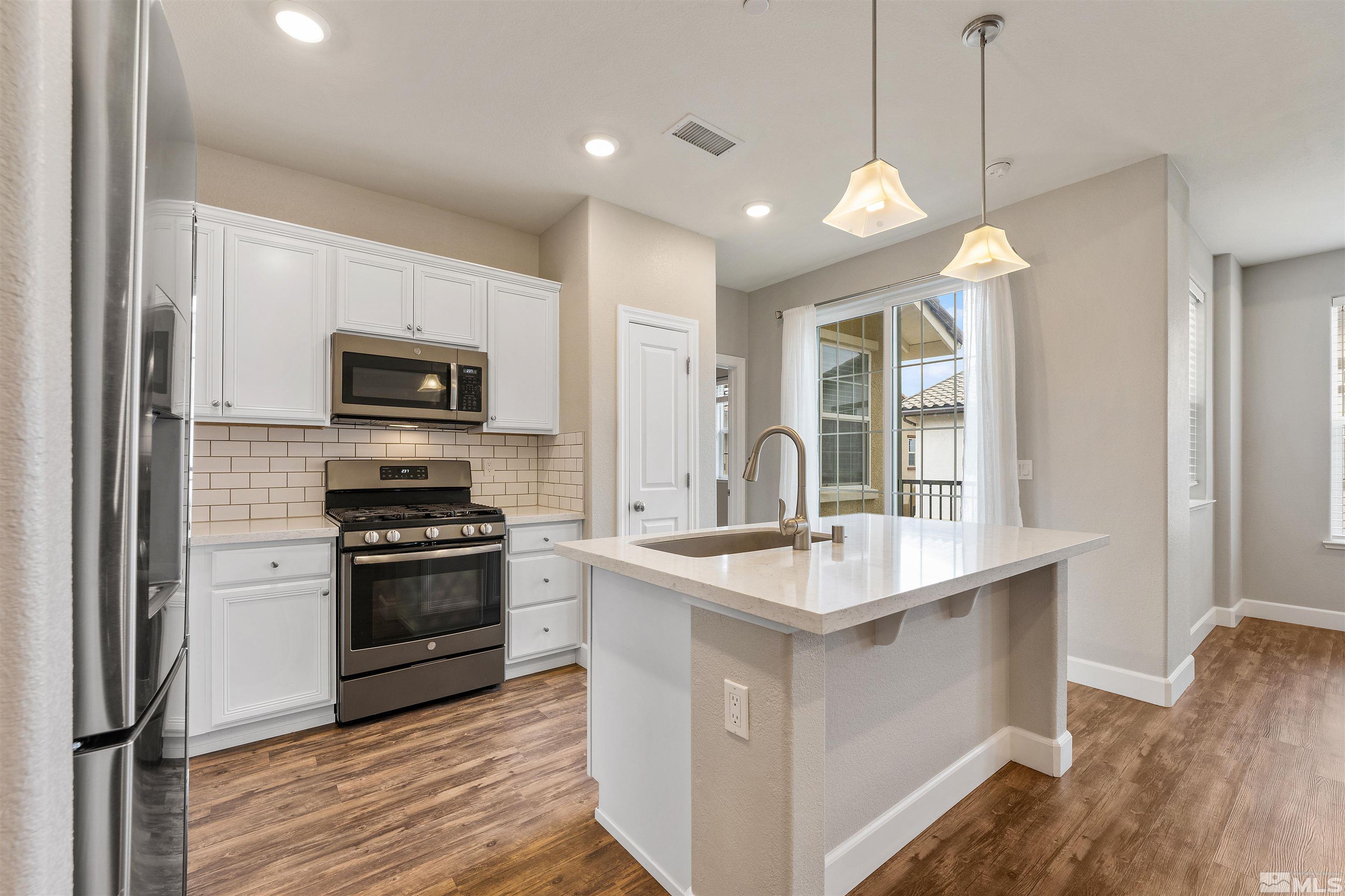1945 Sea Horse Road, Unit A Reno, NV 89521 - Photo 10 of 25 a kitchen with stainless steel appliances granite countertop a sink a stove and a wooden floors