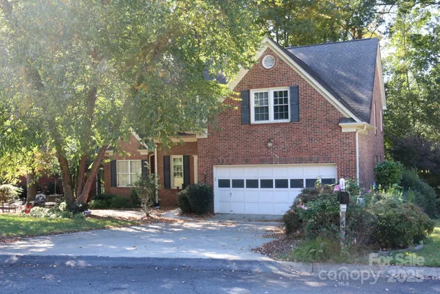 a view of a house with a yard and large tree