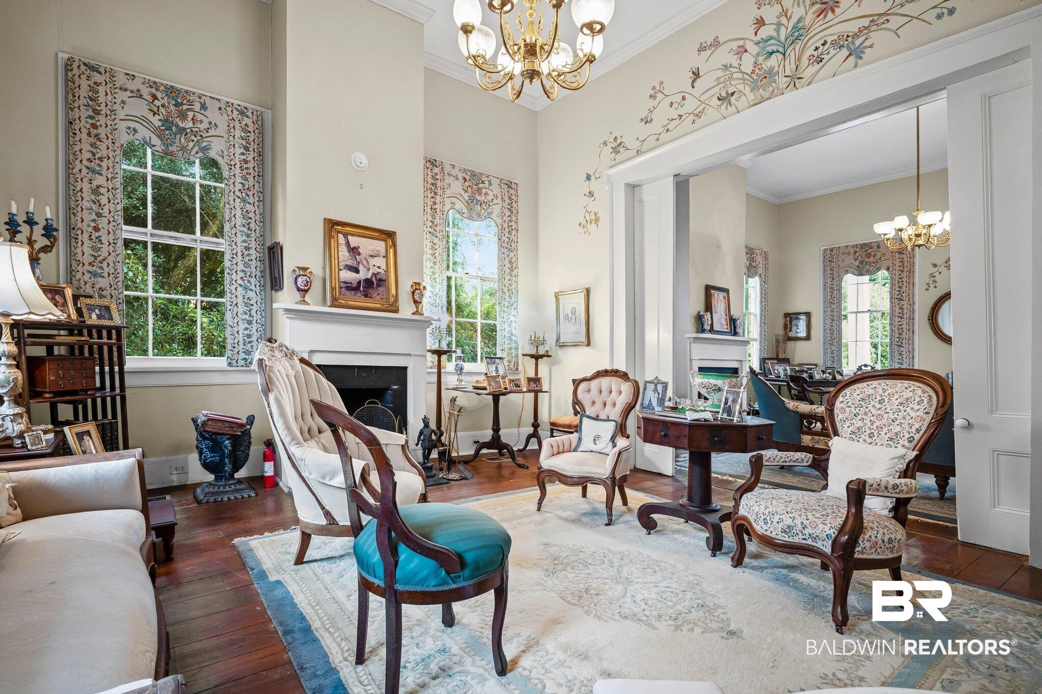 23561 Main Street Fairhope, AL 36532 - Photo 15 of 45 Living area with a chandelier, a fireplace, crown molding, hardwood / wood-style flooring, and a towering ceiling