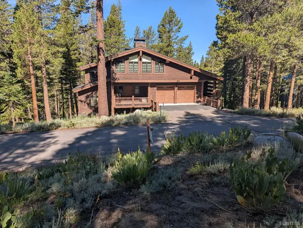 a front view of house with yard and trees around