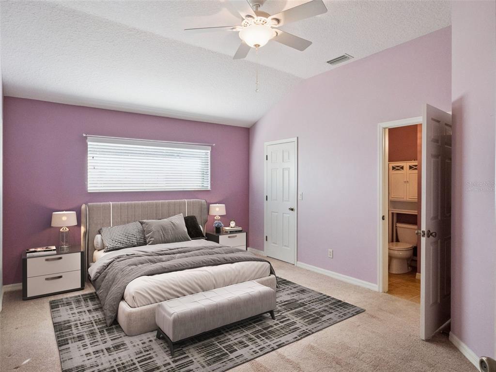 20642 Prince Ranier Place Leesburg, FL 34748 - Photo 14 of 59 a bedroom with a bed and a couch