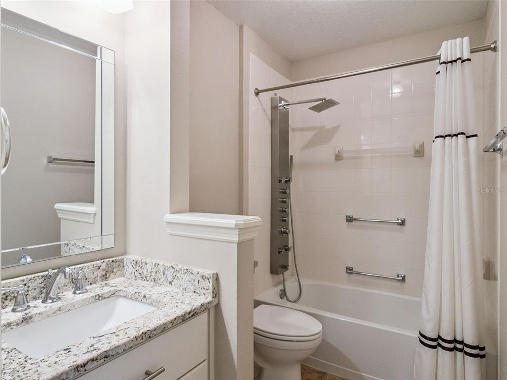20642 Prince Ranier Place Leesburg, FL 34748 - Photo 17 of 59 a bathroom with a granite countertop sink toilet and shower