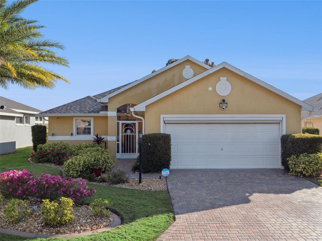 20642 Prince Ranier Place Leesburg, FL 34748 - Photo 2 of 59 a front view of a house with a garden