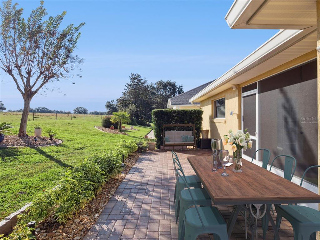 20642 Prince Ranier Place Leesburg, FL 34748 - Photo 21 of 59 a view of a patio with table and chairs potted plants with wooden floor and fence