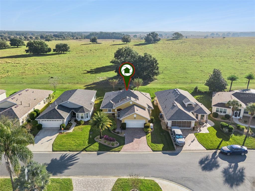 20642 Prince Ranier Place Leesburg, FL 34748 - Photo 29 of 59 an aerial view of a house with garden space and outdoor seating