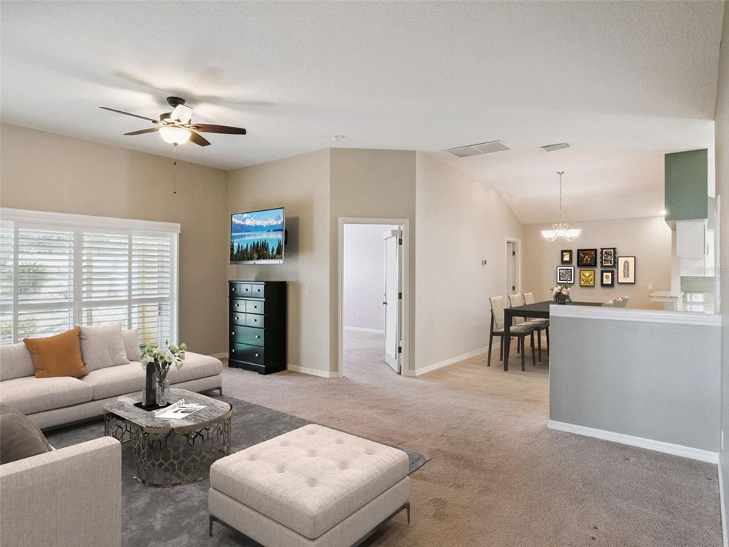 20642 Prince Ranier Place Leesburg, FL 34748 - Photo 6 of 59 a living room with furniture and a chandelier