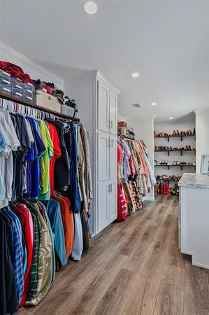 a view of walk in closet with clothes and shoes