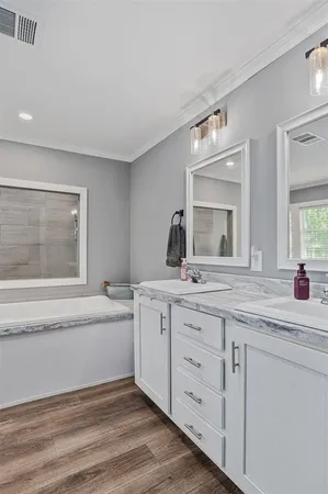 a bathroom with a granite countertop sink mirror and bathtub