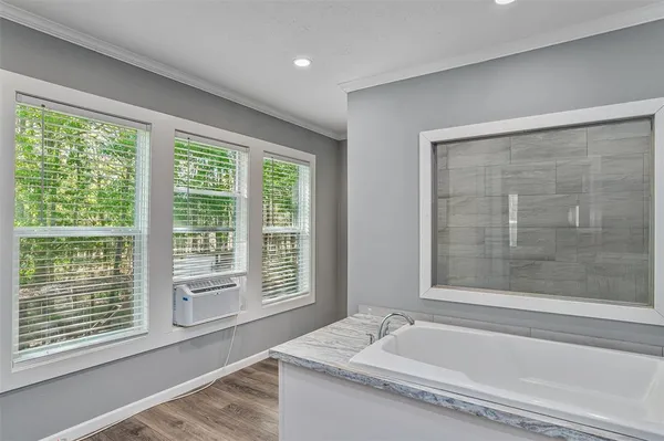 a bathroom with bathtub and window
