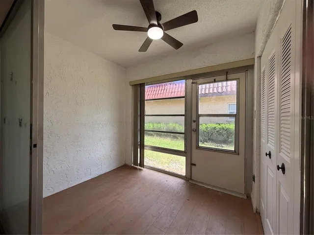 an empty room with a window and a fan