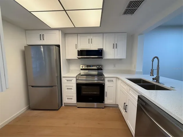 a kitchen with a refrigerator sink and stove
