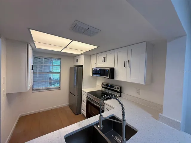 a kitchen with stainless steel appliances a refrigerator and a stove top oven