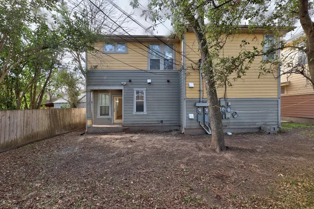 a view of a house with a yard and tree