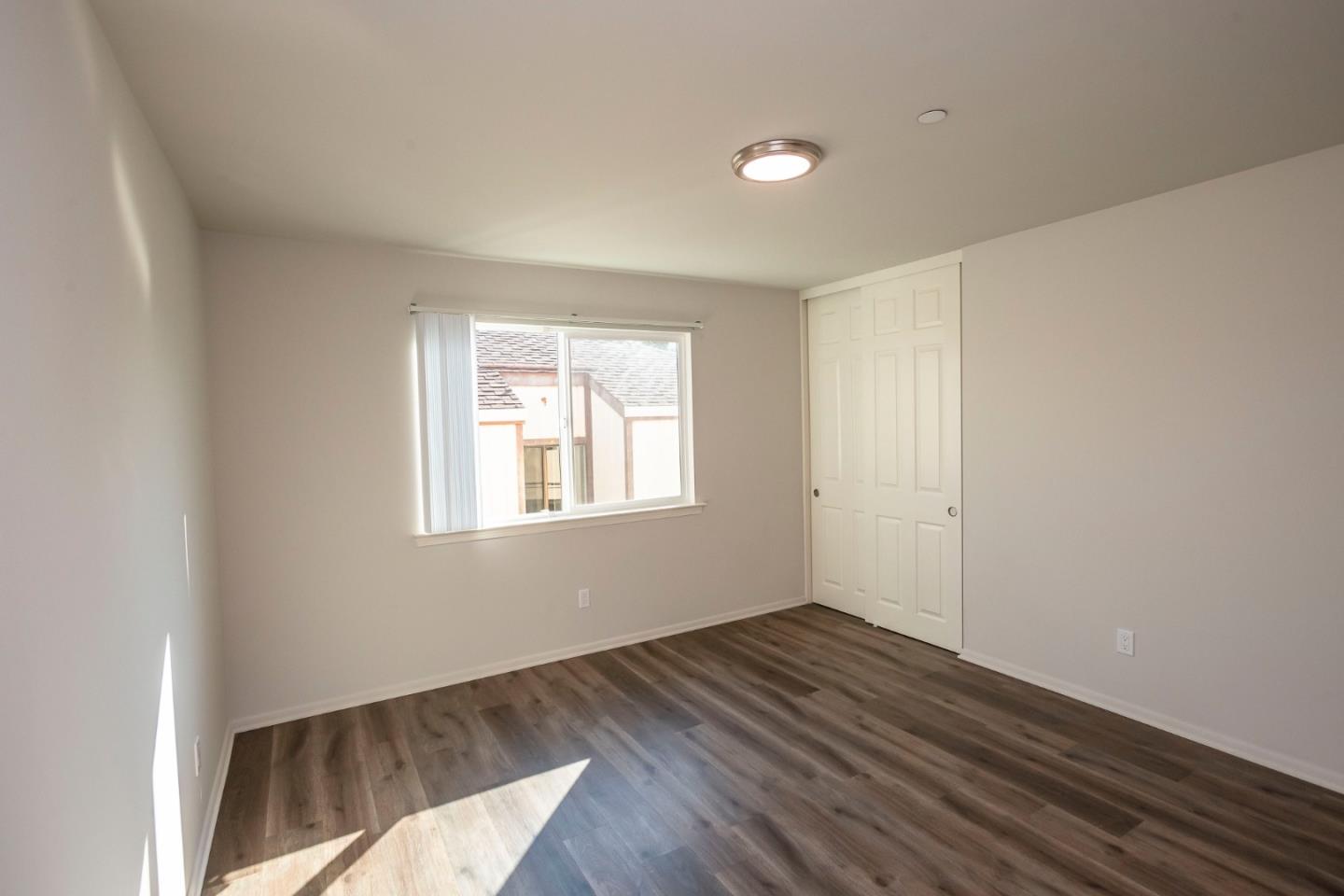 1007 Hemlock Avenue Millbrae, CA 94030 - Photo 16 of 34 a view of an empty room with wooden floor and a window